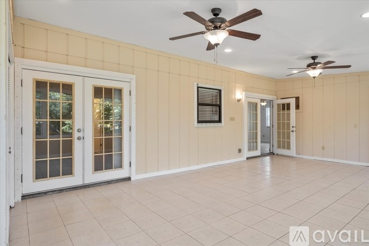 A room with a ceiling fan and tiled flooring.