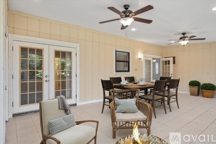 A dining room with a table set for four and a ceiling fan.