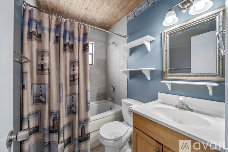 A bathroom with a toilet, sink, and shower curtain.