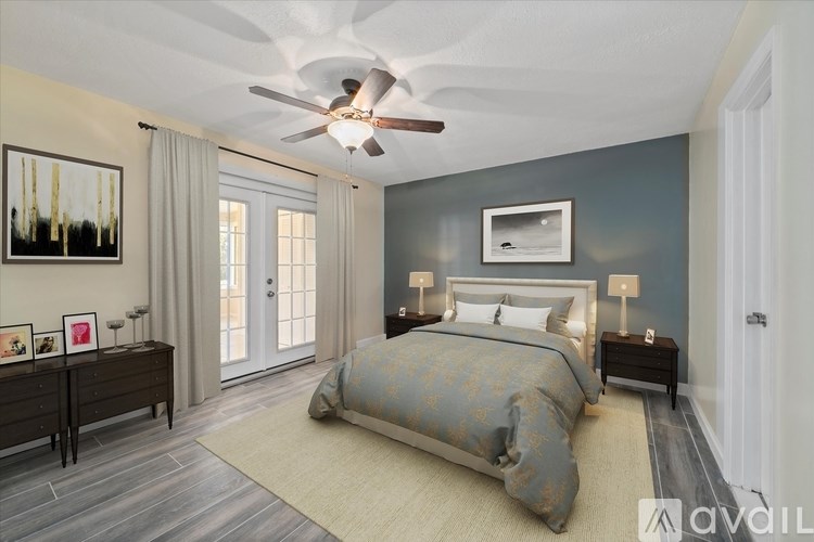 A bedroom with a bed, nightstands, and a ceiling fan.