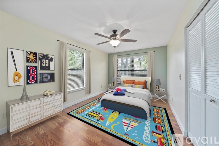 A bedroom with a bed, dresser, and ceiling fan.