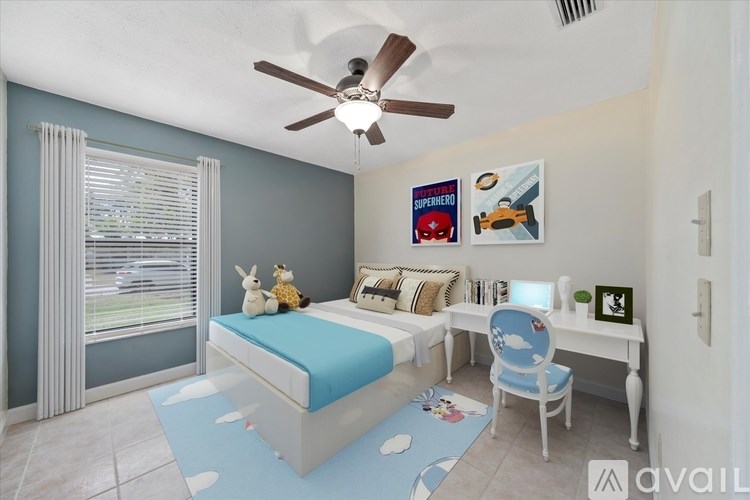 A bedroom with a bed, desk, chair, and a ceiling fan.