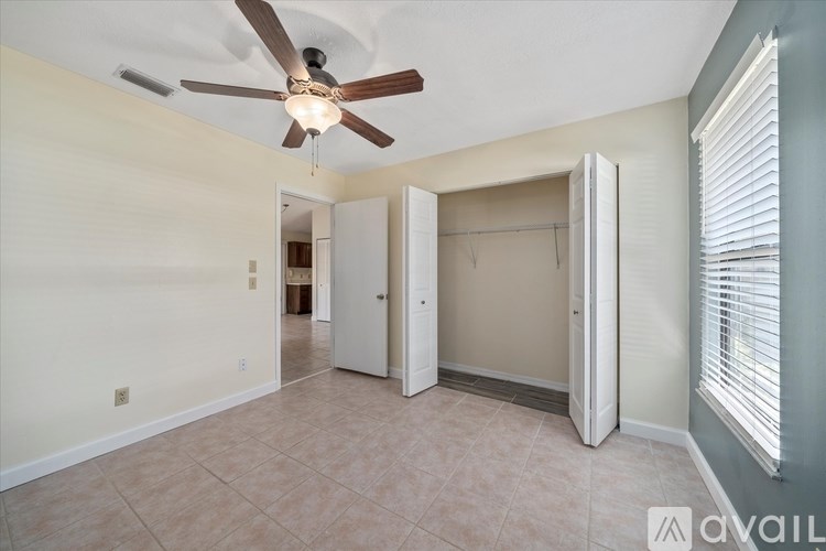 A room with a ceiling fan and a doorway leading to another room.