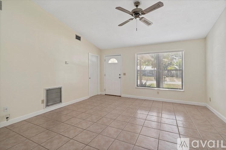 A room with a ceiling fan and tile flooring.