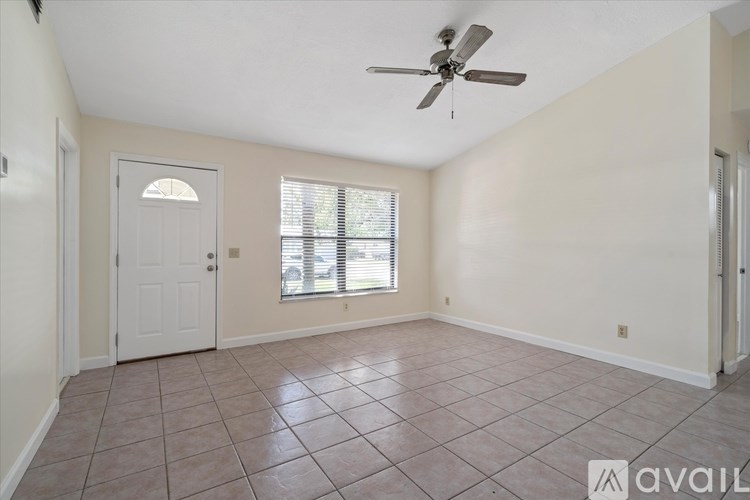 A room with a ceiling fan and a window with blinds.