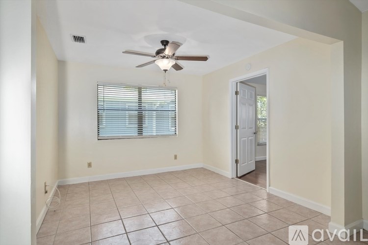 A room with a ceiling fan and a window with blinds.
