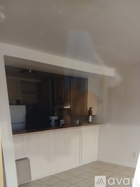 A kitchen with white cabinets and a white tiled floor.