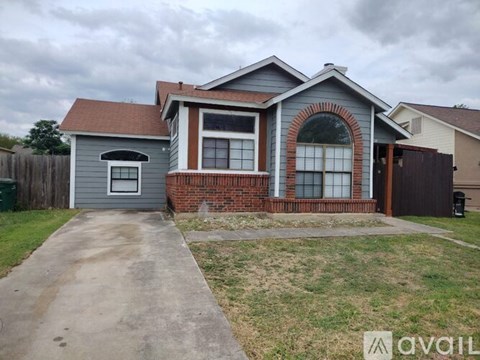 A house with a grey garage and a brick wall.
