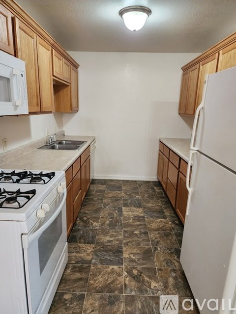 A kitchen with a white stove and white refrigerator.