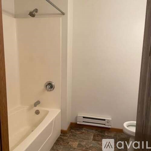 A bathroom with a white bathtub and a toilet.