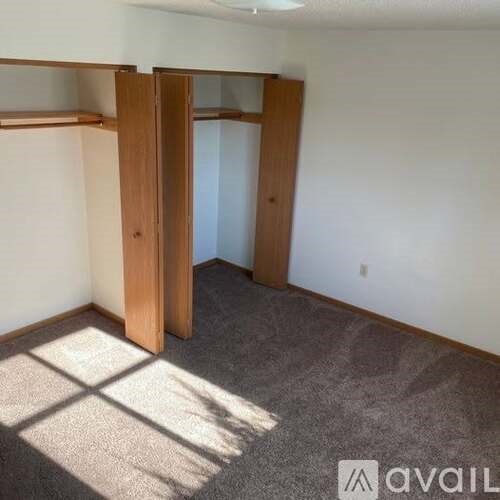 A room with a carpeted floor and a wall-mounted shelf.