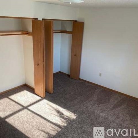 A room with a carpeted floor and a wall-mounted shelf.