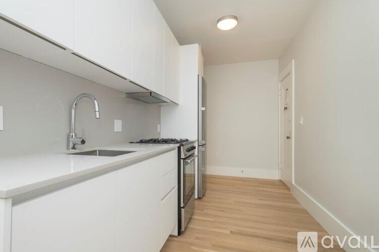 A kitchen with white cabinets and a black stove top oven.