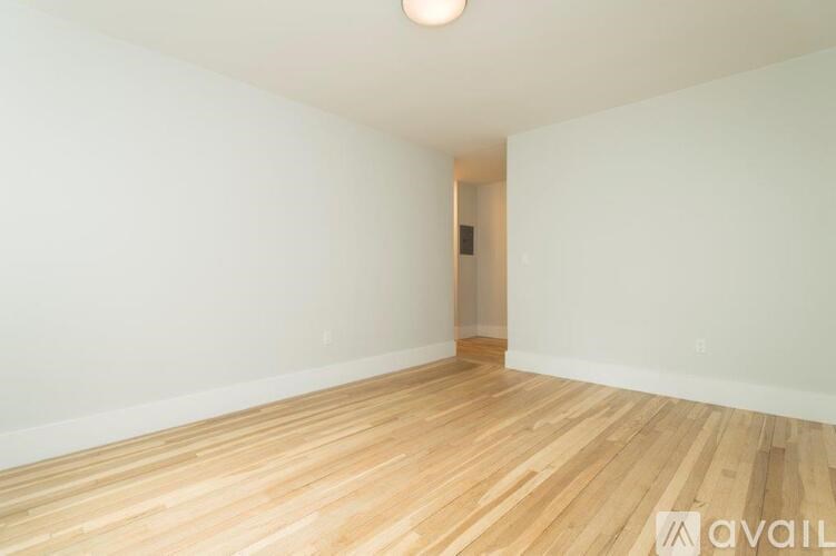 A room with wooden flooring and white walls.