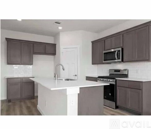 A kitchen with brown cabinets and white countertops.
