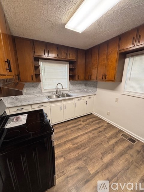 A kitchen with wooden cabinets and a black dishwasher.