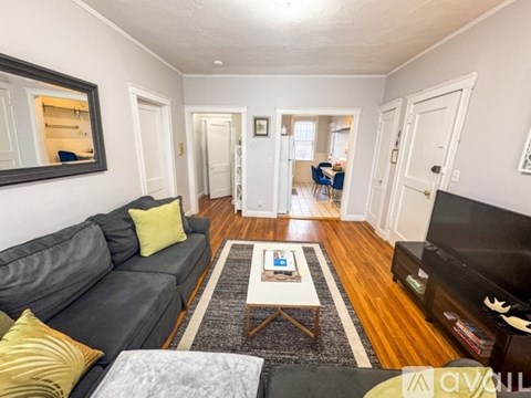 A living room with a grey couch and a coffee table in the middle.