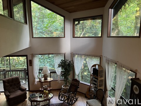 A living room with a balcony and a table with a lamp.
