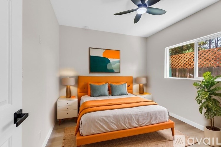 A bedroom with a large bed and a ceiling fan.