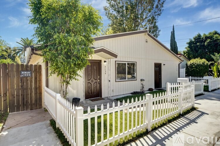A house with a white picket fence is for sale.