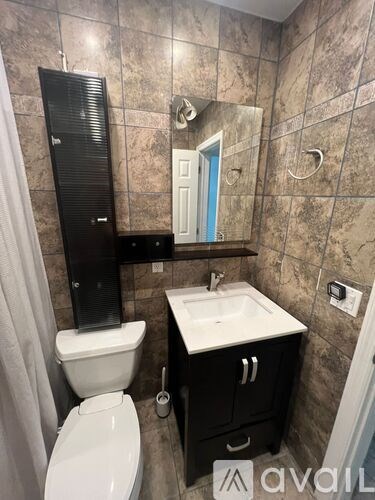 A bathroom with a toilet, sink, and mirror.