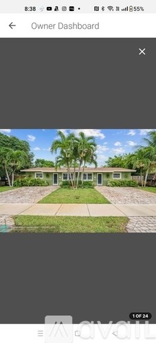 A house with a green lawn and trees in front.