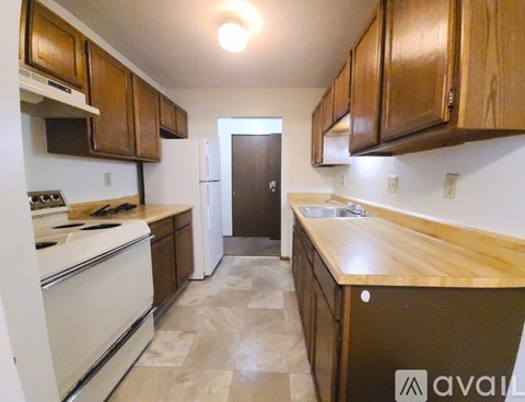 A kitchen with wooden cabinets and a white stove top oven.