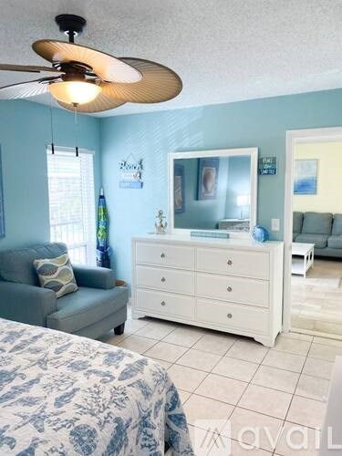 A bedroom with a bed, dresser, and couch.