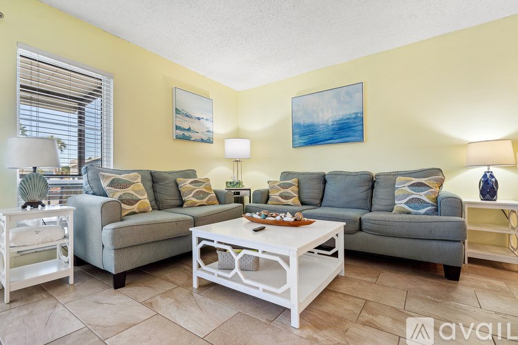A bathroom with a toilet, sink, and a painting of a person on a surfboard.