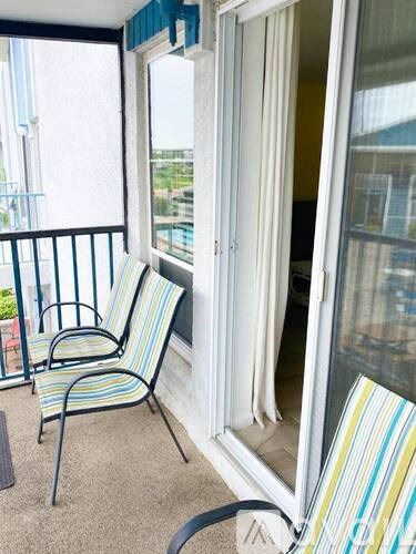Two striped chairs are on a balcony.