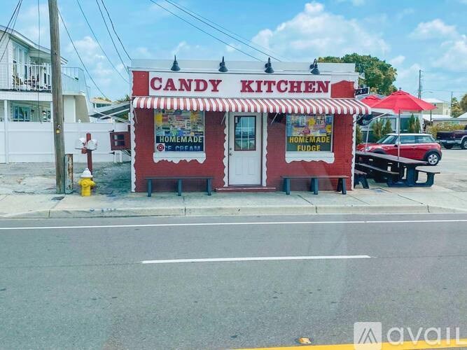 A candy kitchen storefront with a red and white striped awning.