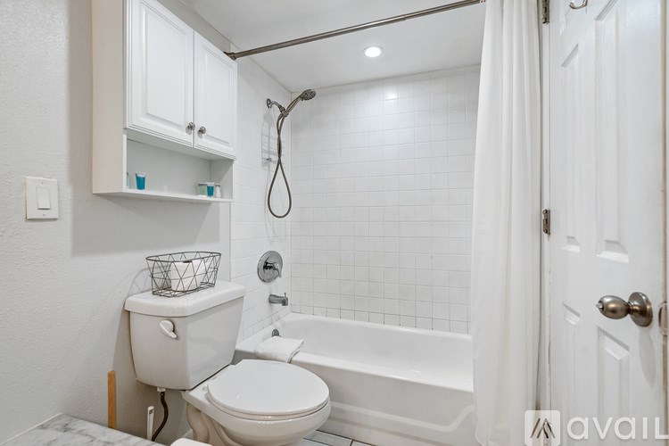 A white bathroom with a toilet, a tub, and a shower.