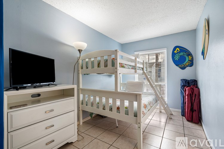 A baby's room with a crib, dresser, and a television.