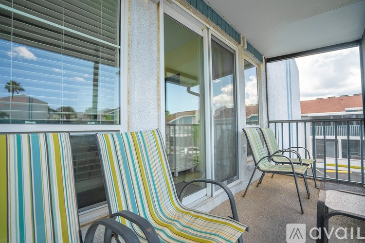 Two striped chairs are on a balcony.