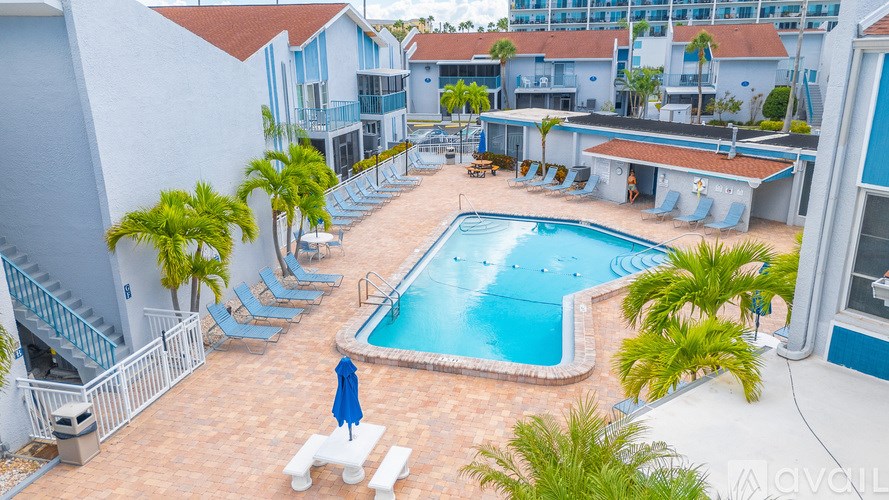 A pool surrounded by lounge chairs and umbrellas.