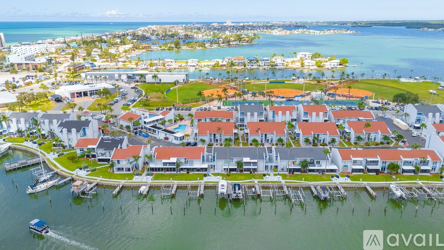 A bird's eye view of a waterfront residential area with boats docked at the marina.