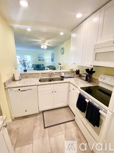 A kitchen with white cabinets and appliances.