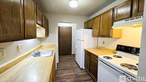 A kitchen with wooden cabinets and a white refrigerator.