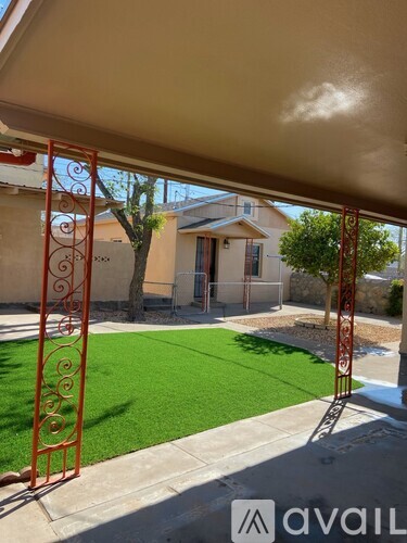 A house with a green lawn and a red gate.