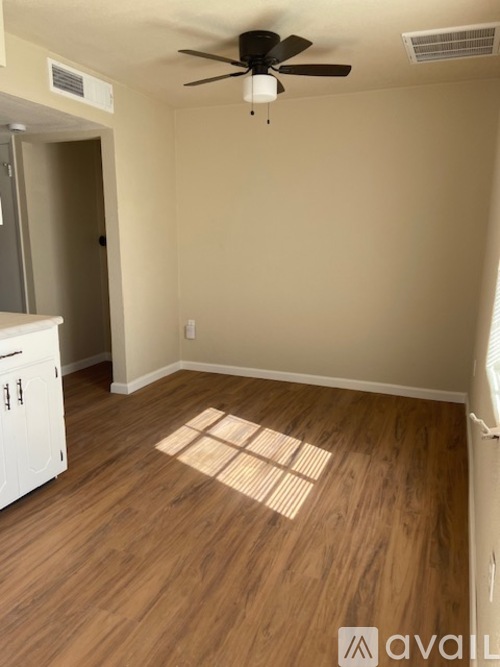 A room with wooden flooring and a ceiling fan.