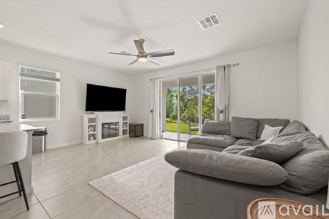 A living room with a grey couch and a flat screen TV.