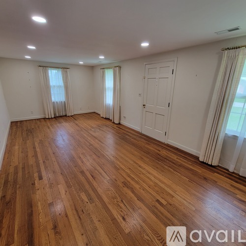 A room with wooden flooring and white walls.