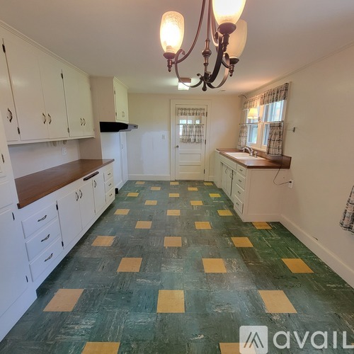 A kitchen with green and yellow tiles on the floor.