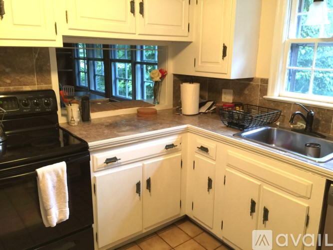 A kitchen with white cabinets and a black stove top oven.