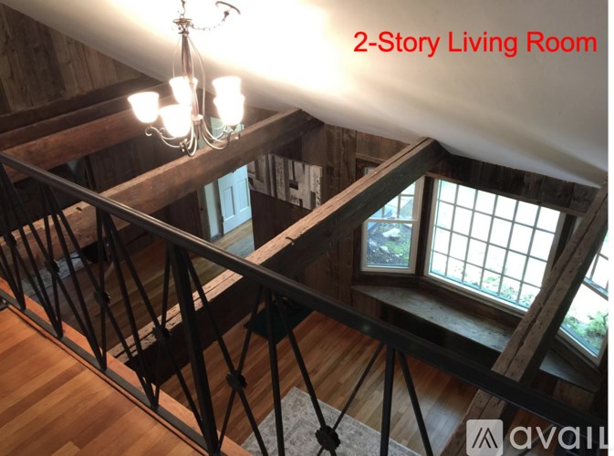 A living room with a staircase and a chandelier.