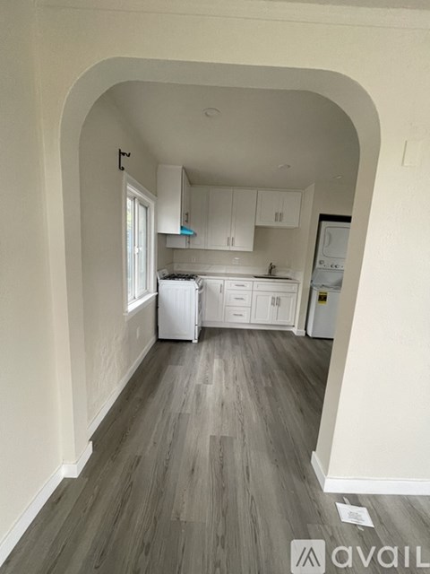 A kitchen with white cabinets and a refrigerator.
