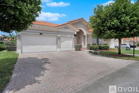 A house with a red tile roof and a white garage door is for sale.