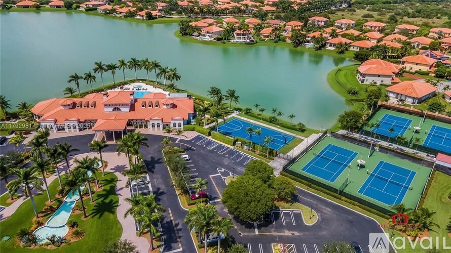 A bird's eye view of a resort with a swimming pool, tennis courts, and a lake.