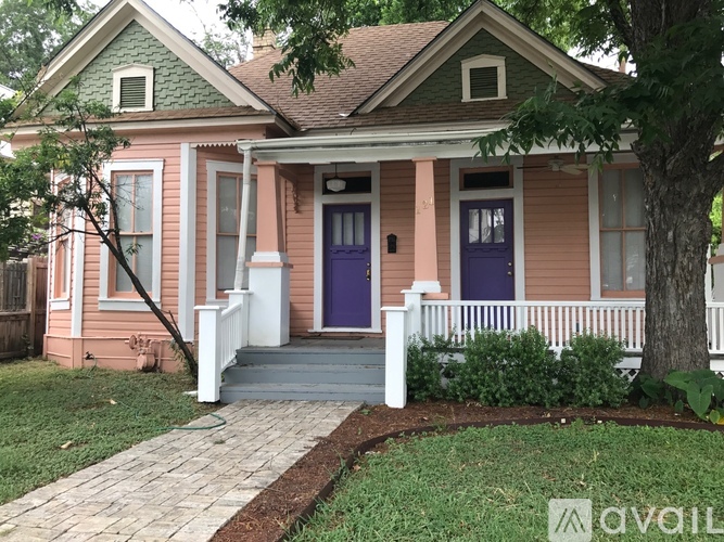 A house with a purple door and white railings.
