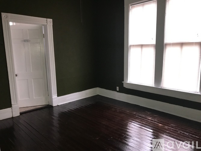 A room with a white door and a window with blinds.